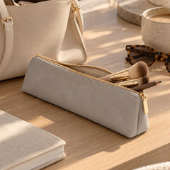 Dove grey brush pouch with makeup brushes on a wooden table